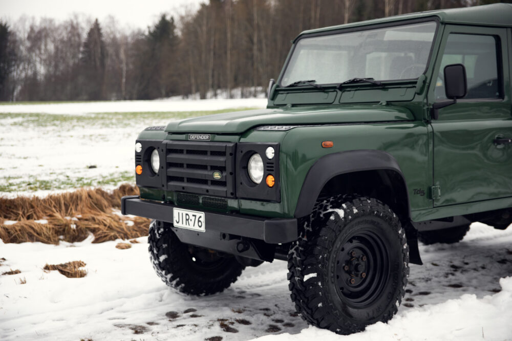 Green Land Rover Defender on snowy field