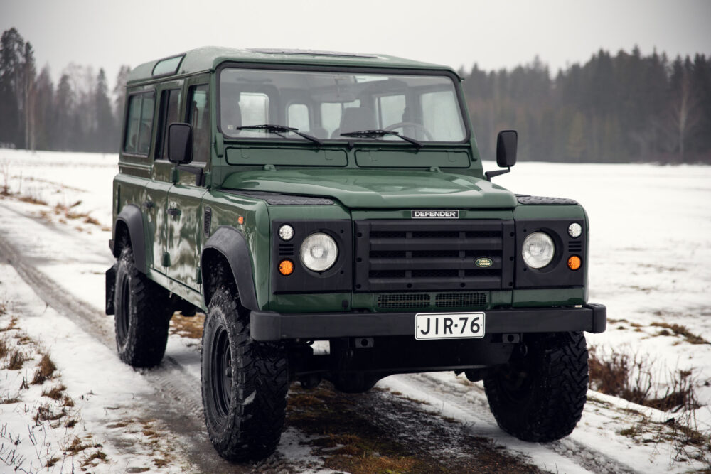 Green Land Rover Defender on snowy road