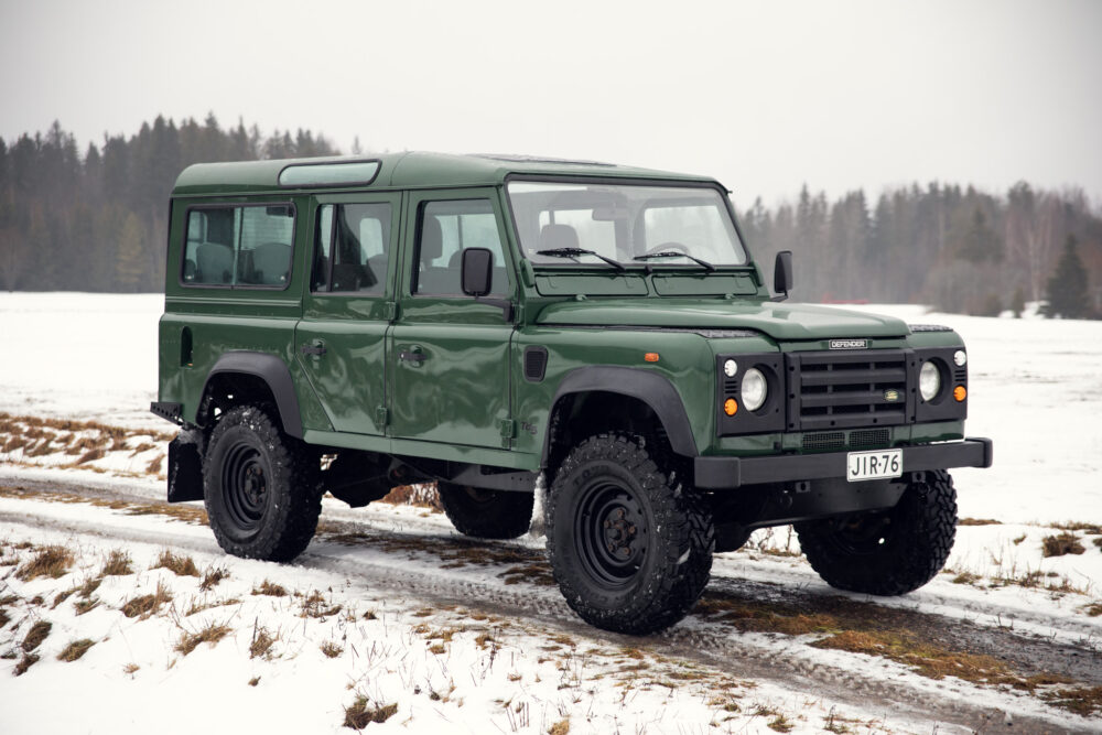 Green Land Rover Defender on snowy field