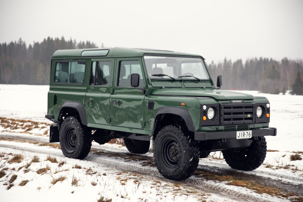 Green Land Rover Defender on snowy field