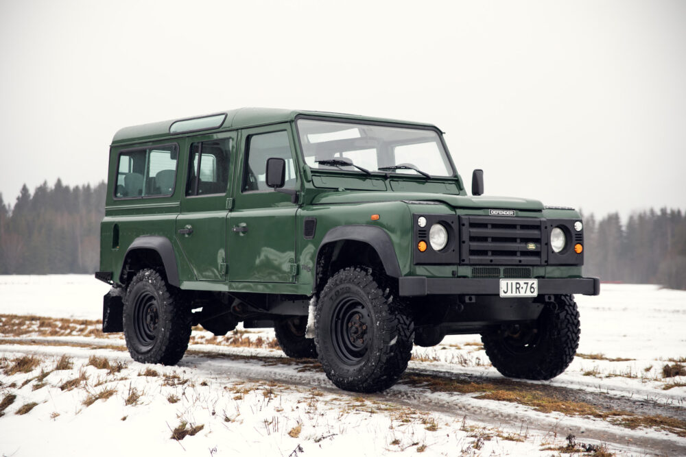 Green Land Rover Defender on snowy field