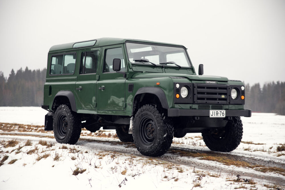 Green Land Rover Defender on snowy field