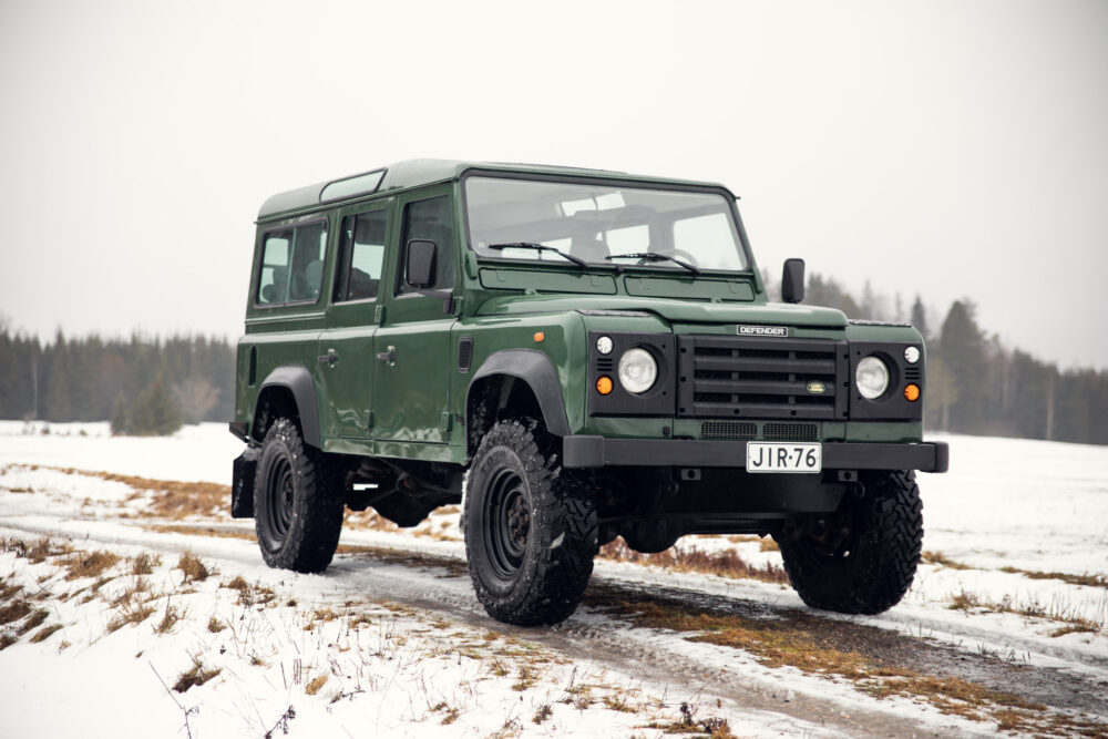 Green Land Rover Defender on snowy field