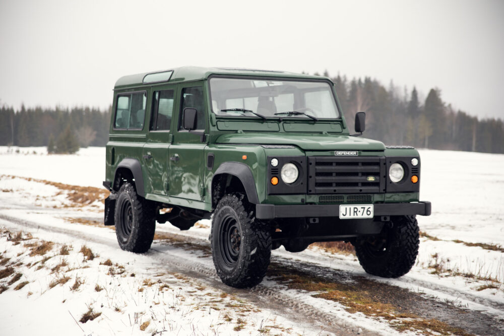 Green Land Rover Defender on snowy road