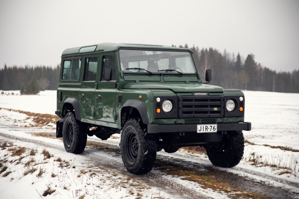 Green Land Rover Defender on snowy field