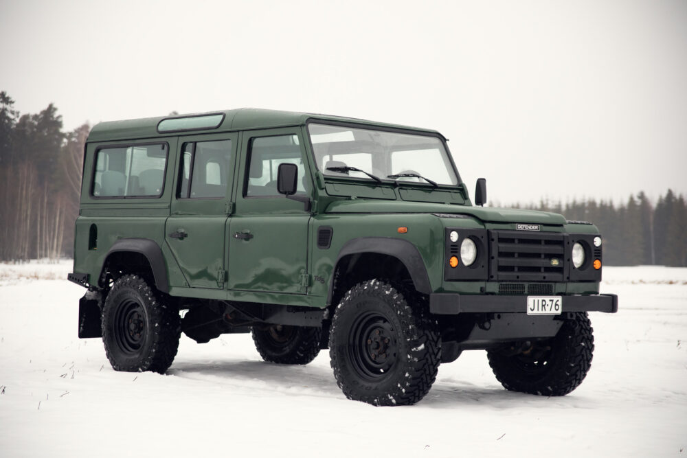 Green Land Rover Defender in snowy field