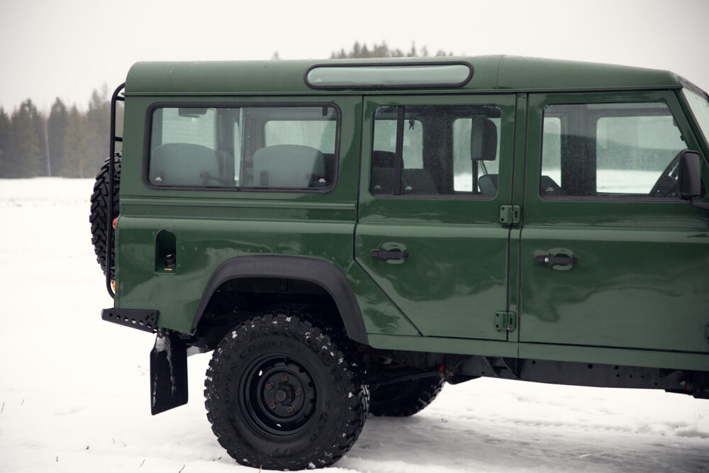 Green SUV parked on snowy field