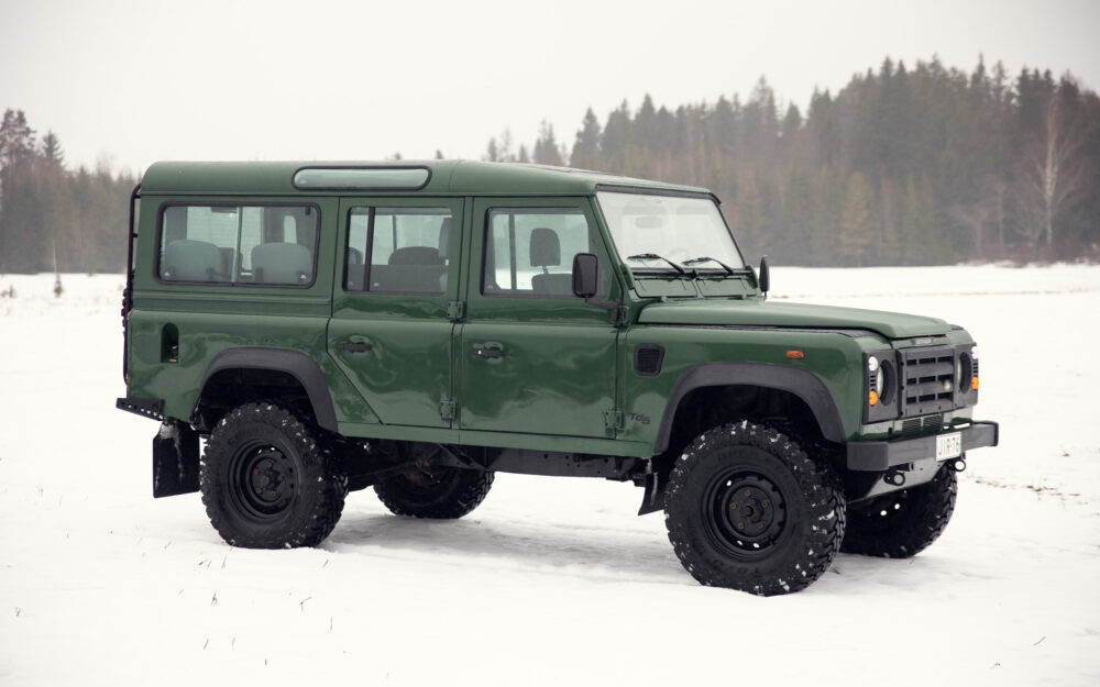 Green off-road vehicle in snowy forest