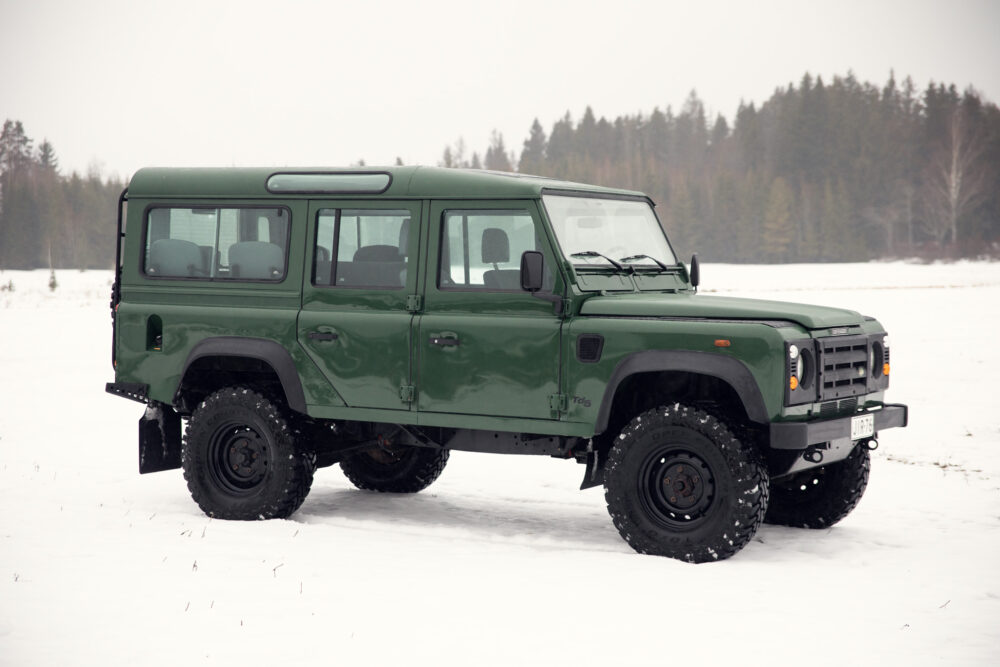 Green off-road vehicle in snowy forest