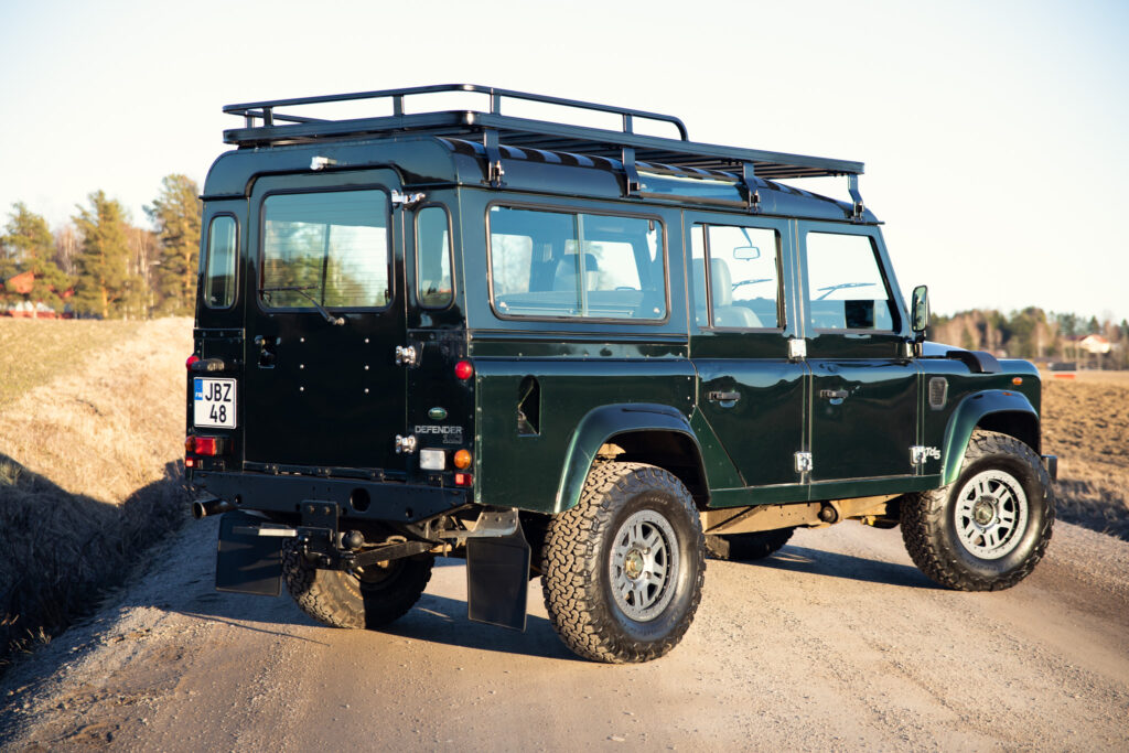 Green Land Rover Defender on dirt road