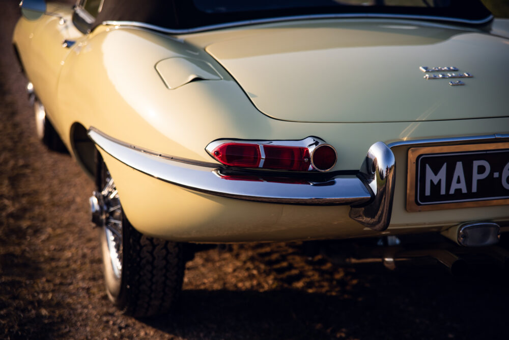 Vintage cream sports car rear close-up, sunset lighting