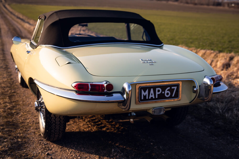 Vintage yellow Jaguar convertible parked on rural road