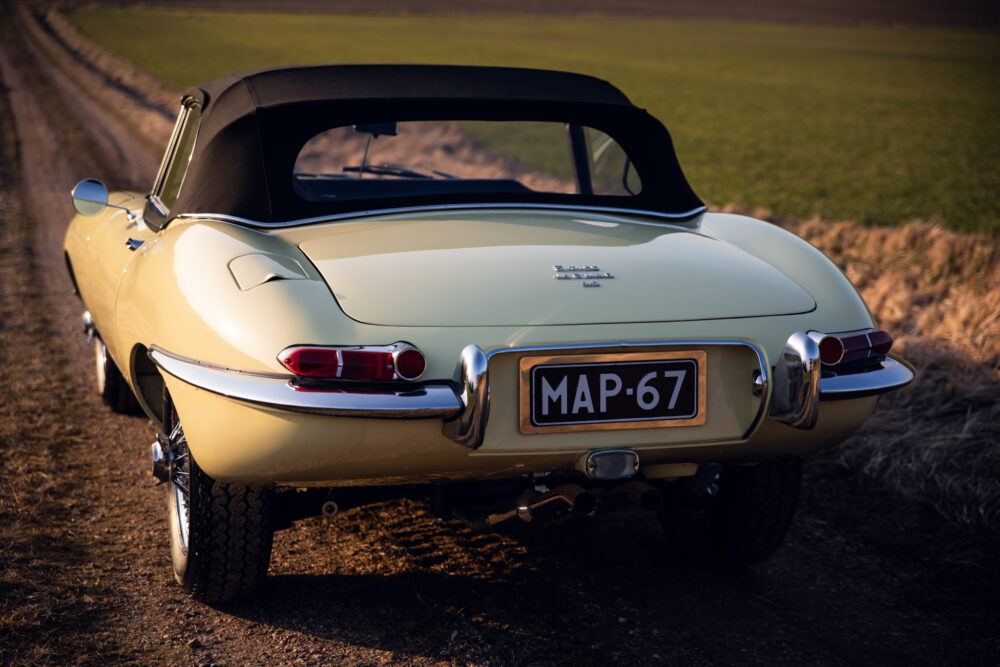 Vintage yellow convertible car on rural road at sunset