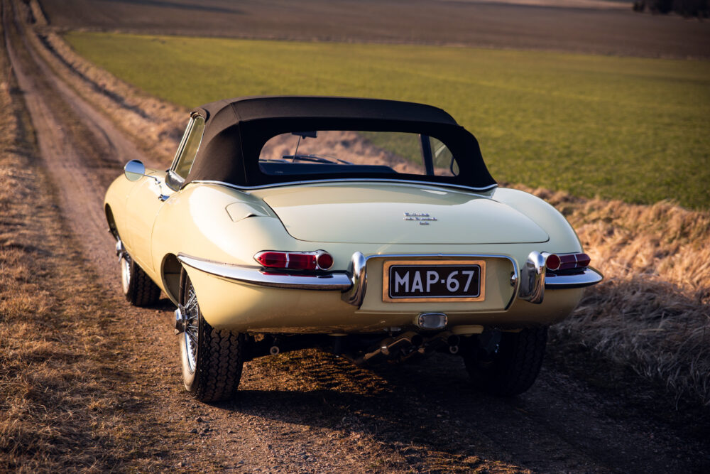 Vintage yellow car on rural road at sunset