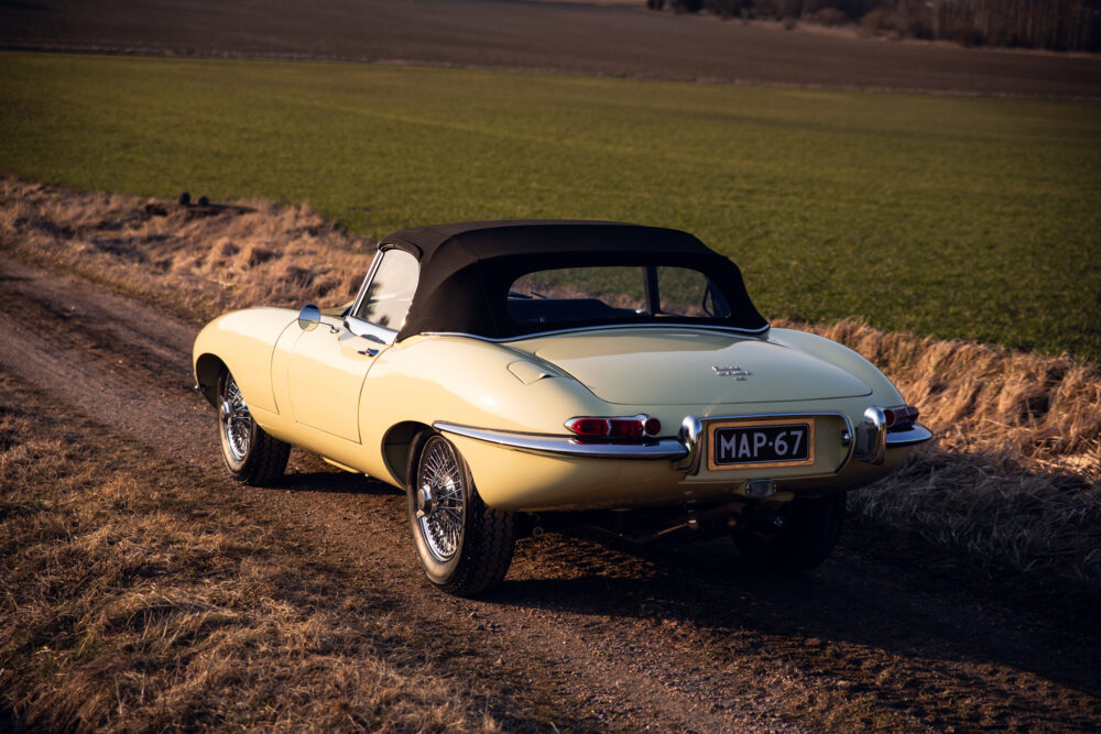 Vintage yellow Jaguar E-Type convertible on country road