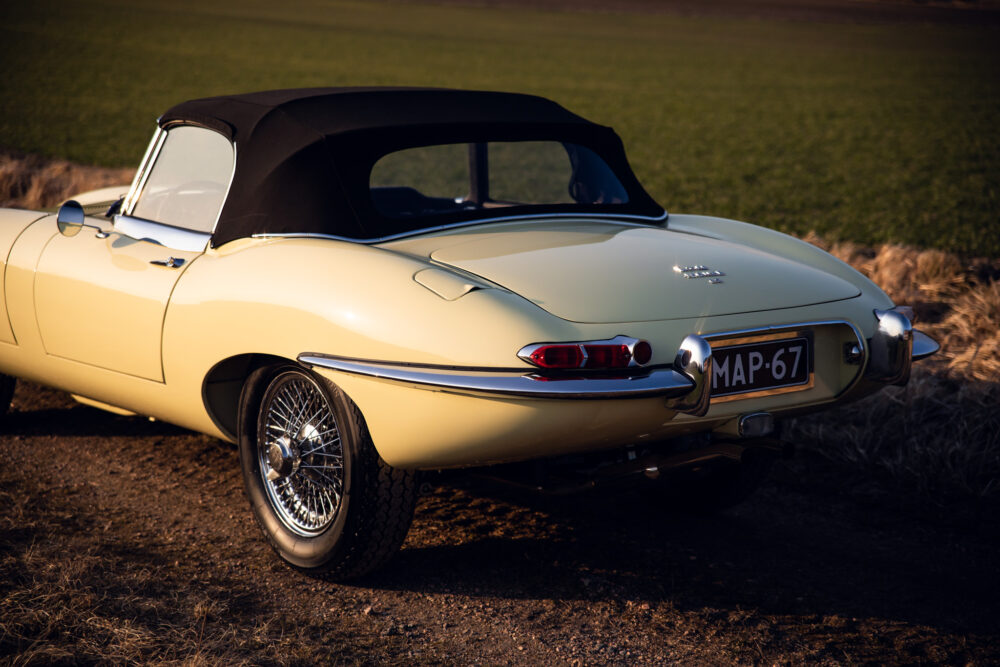 Vintage yellow convertible car parked in field at dusk