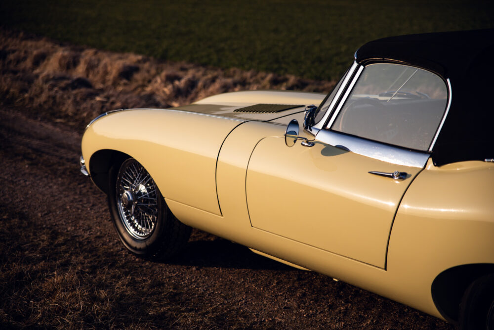 Vintage yellow convertible car parked near field