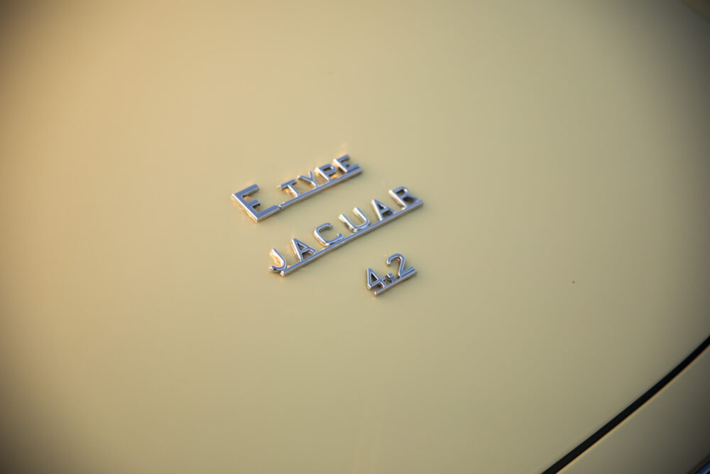 E-Type Jaguar 4.2 emblem on beige car