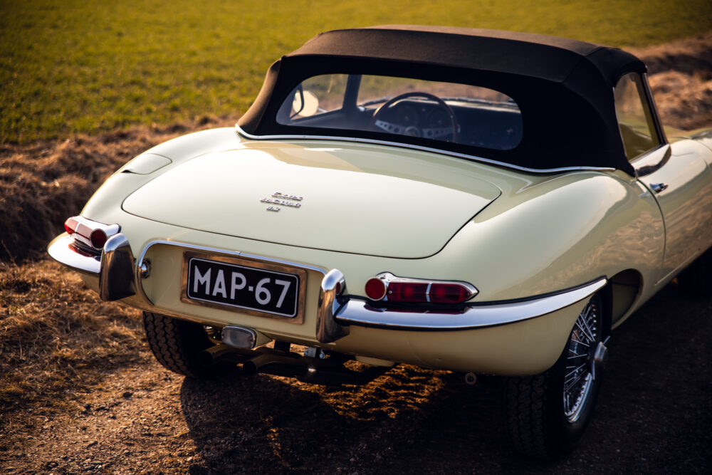 Vintage cream convertible car on grass during sunset