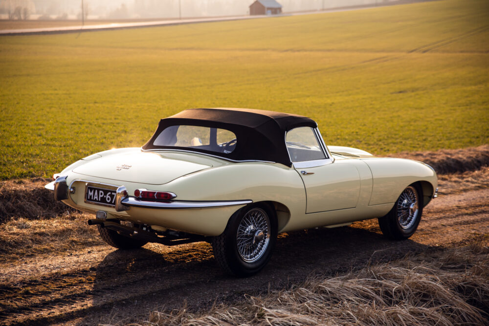 Vintage cream convertible car in a golden field at sunset