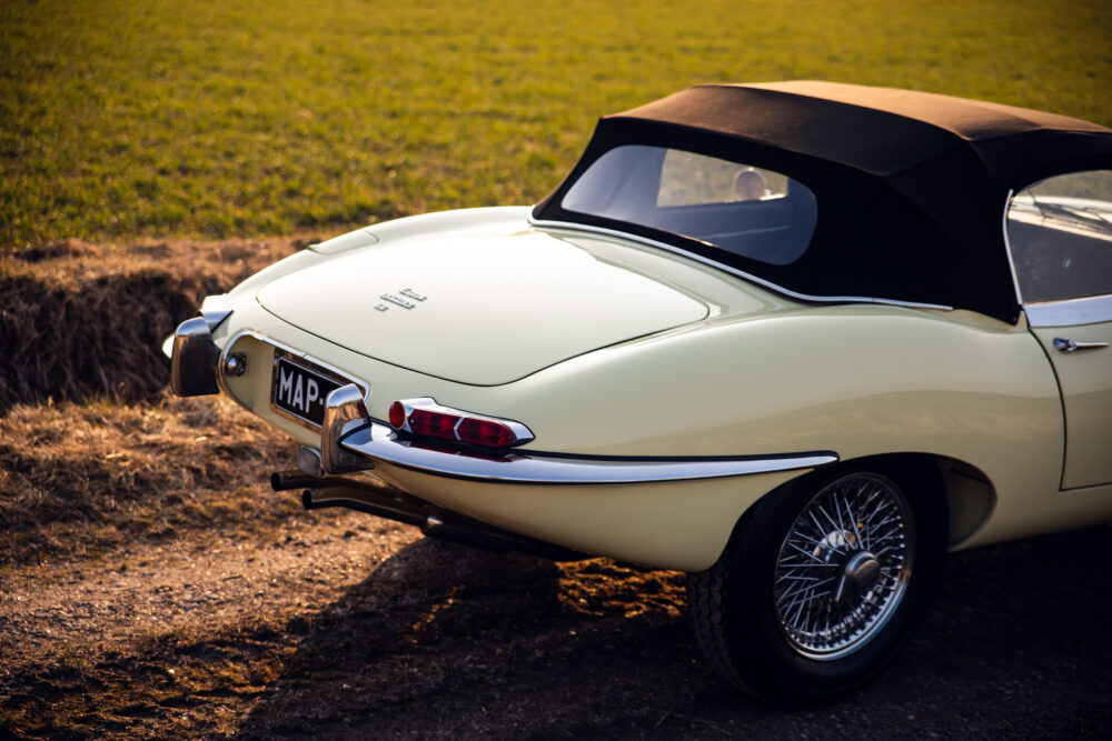 Vintage cream convertible car parked on grassy field