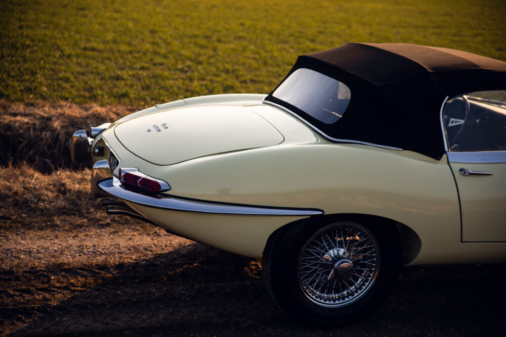 Vintage cream convertible car parked in grassy field
