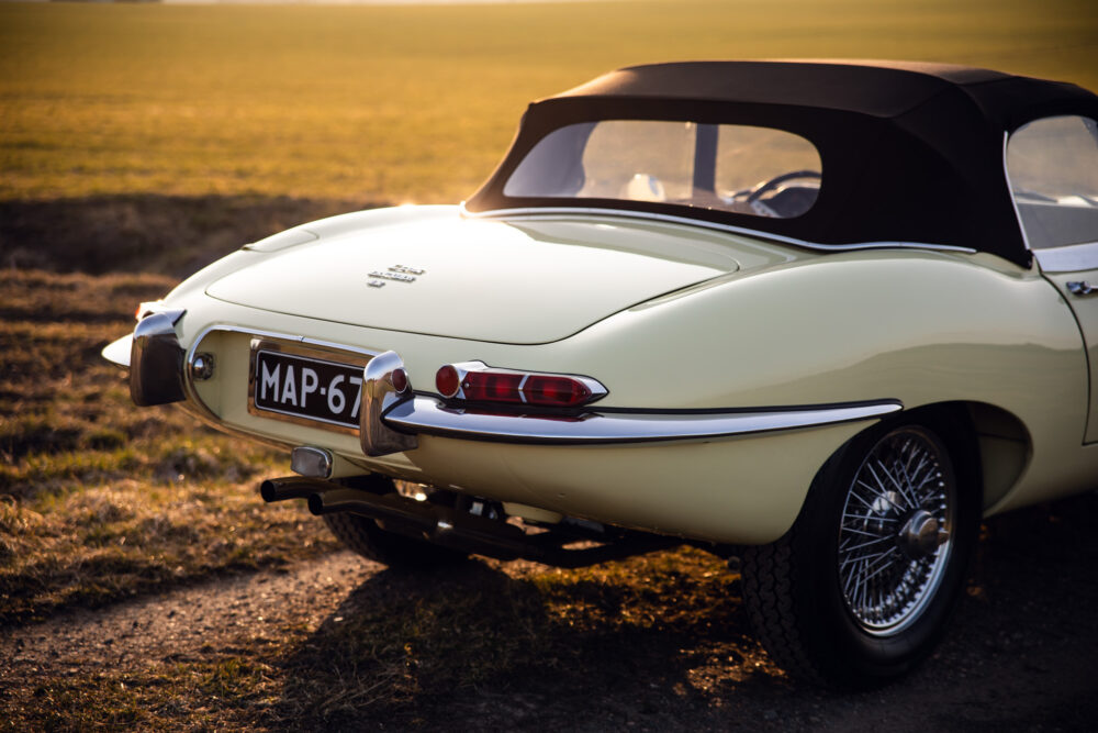 Vintage cream convertible car at sunset in field