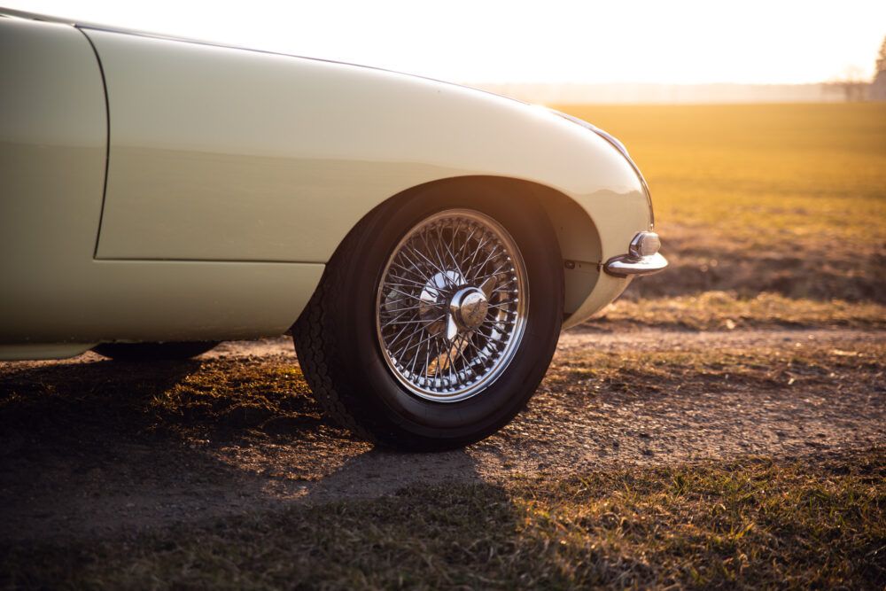 Vintage car wheel at sunset in open field