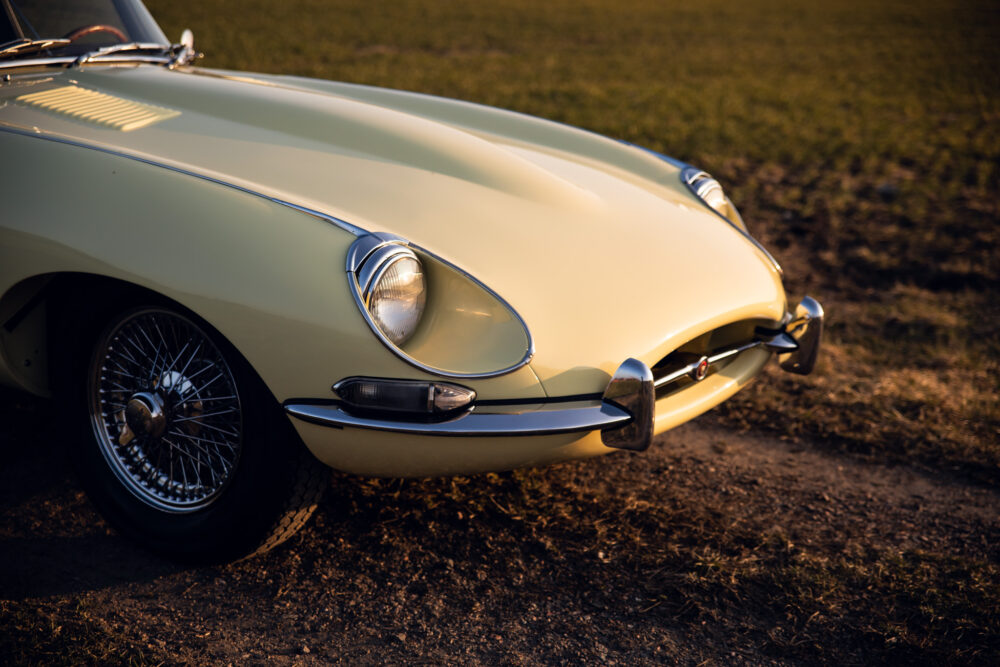 Vintage yellow sports car on grass at sunset