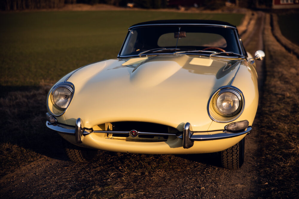 Vintage cream Jaguar E-Type car on a dirt road