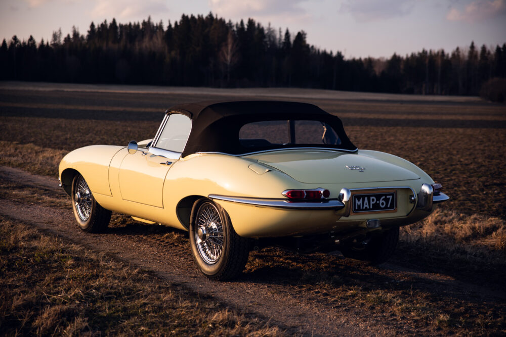 Vintage yellow convertible car in open field at dusk
