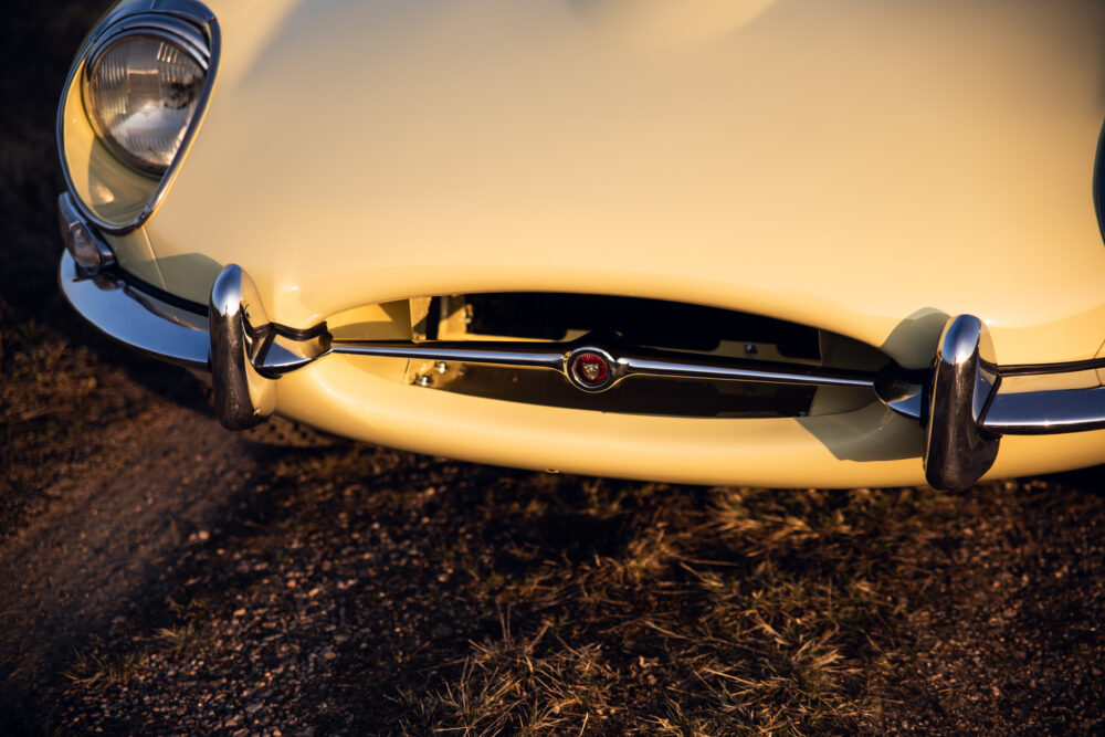 Close-up of vintage cream car's front grille and headlight