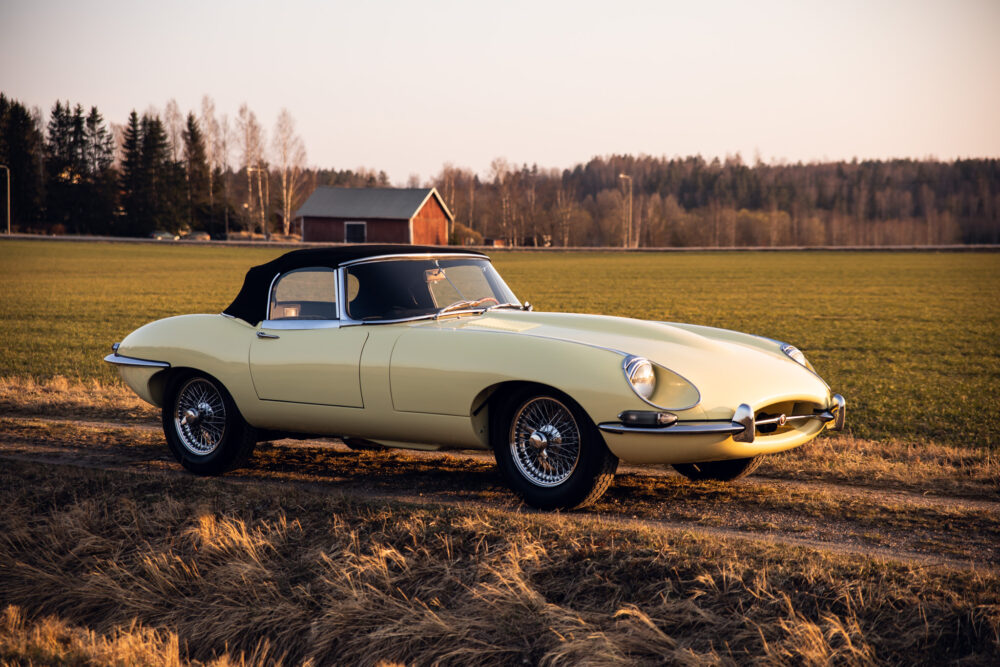 Vintage yellow convertible car in rural field at sunset