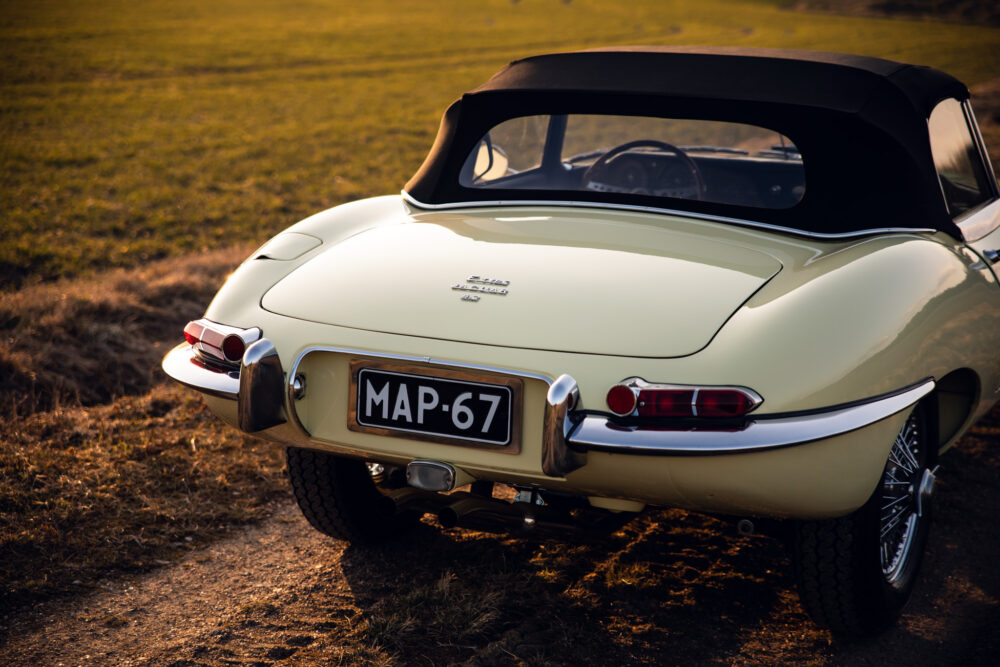 Vintage cream Jaguar E-Type convertible in field