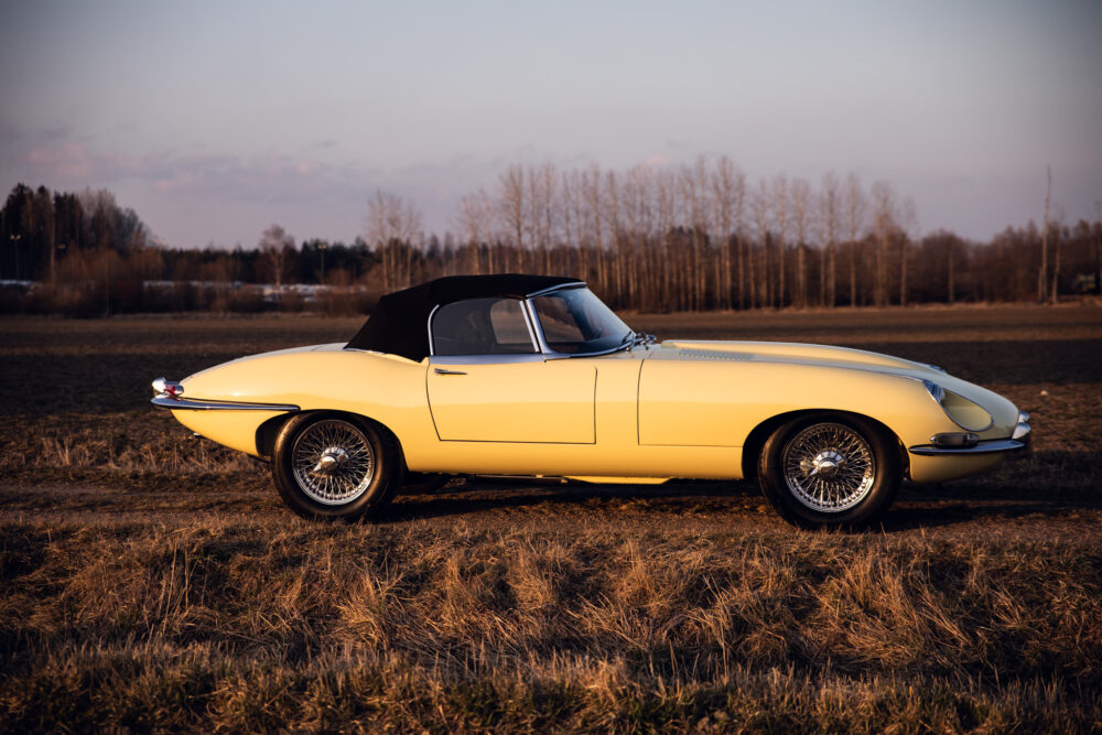 Vintage yellow convertible car in open field at dusk