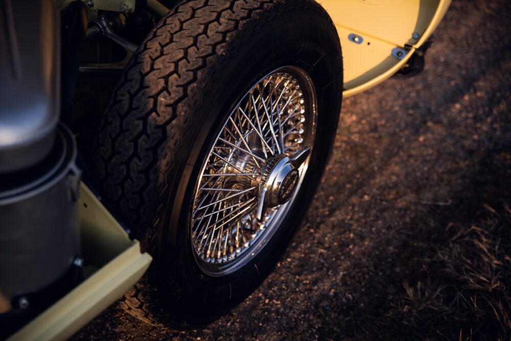 Classic car's wheel with detailed spokes on dirt road