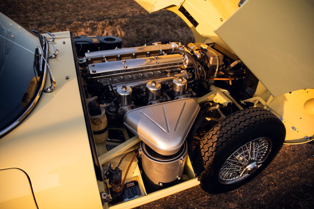Vintage car engine and wheel exposed at sunset