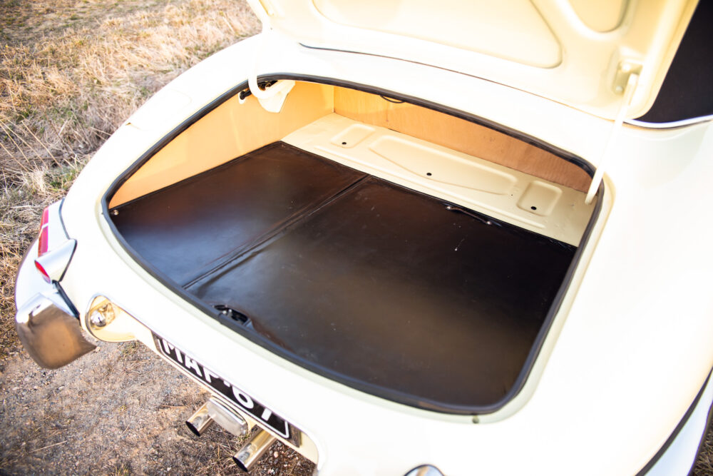 Open trunk of vintage cream car showing empty space
