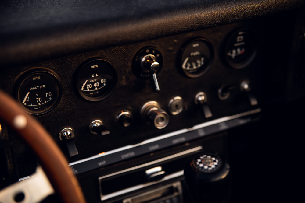 Vintage car dashboard with gauges and wooden steering wheel