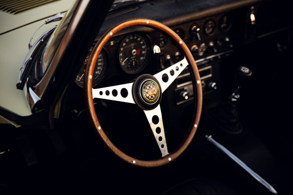 Vintage car's wooden steering wheel and dashboard details