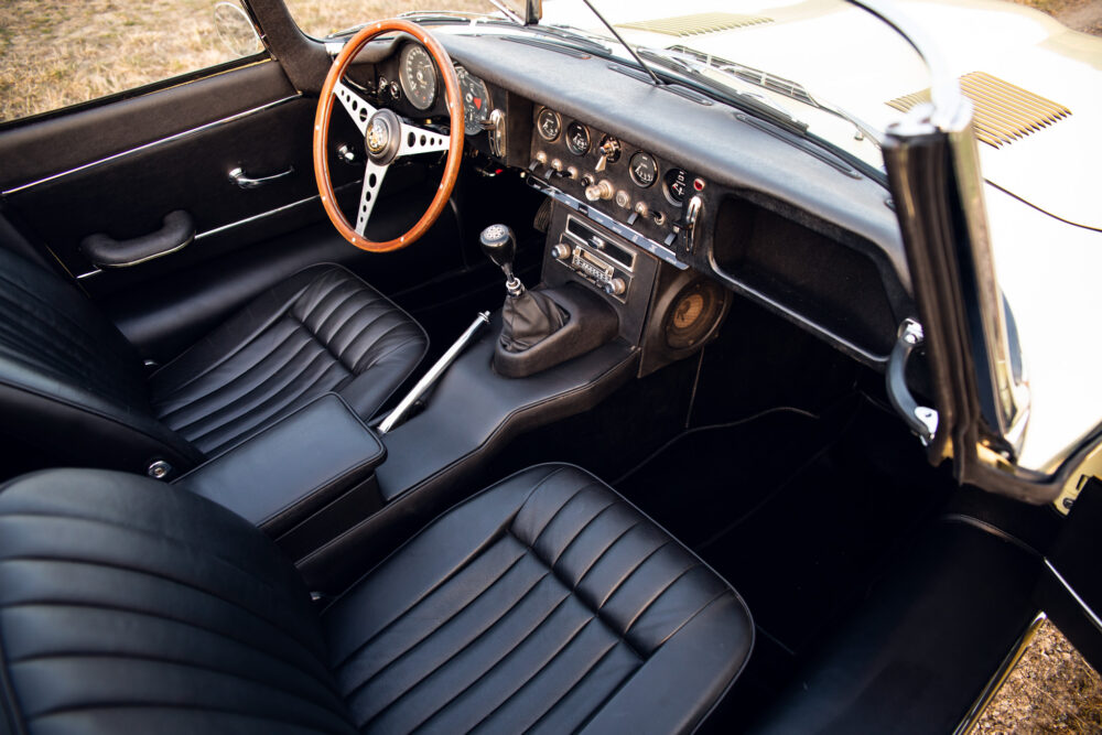 Classic car interior with leather seats and wooden wheel