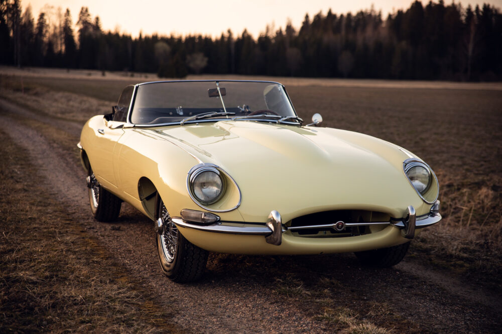 Vintage yellow Jaguar convertible parked in countryside