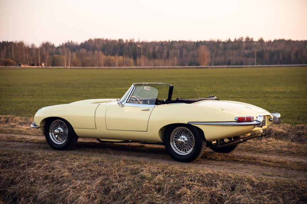 Vintage yellow convertible car in open field at dusk