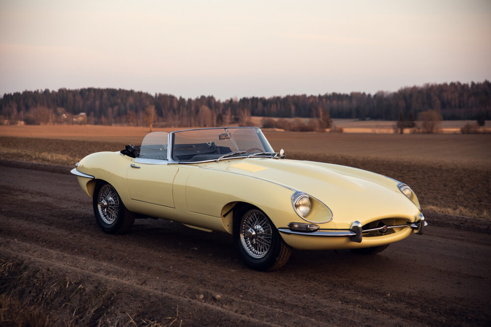 Vintage yellow convertible car in rural field at dusk