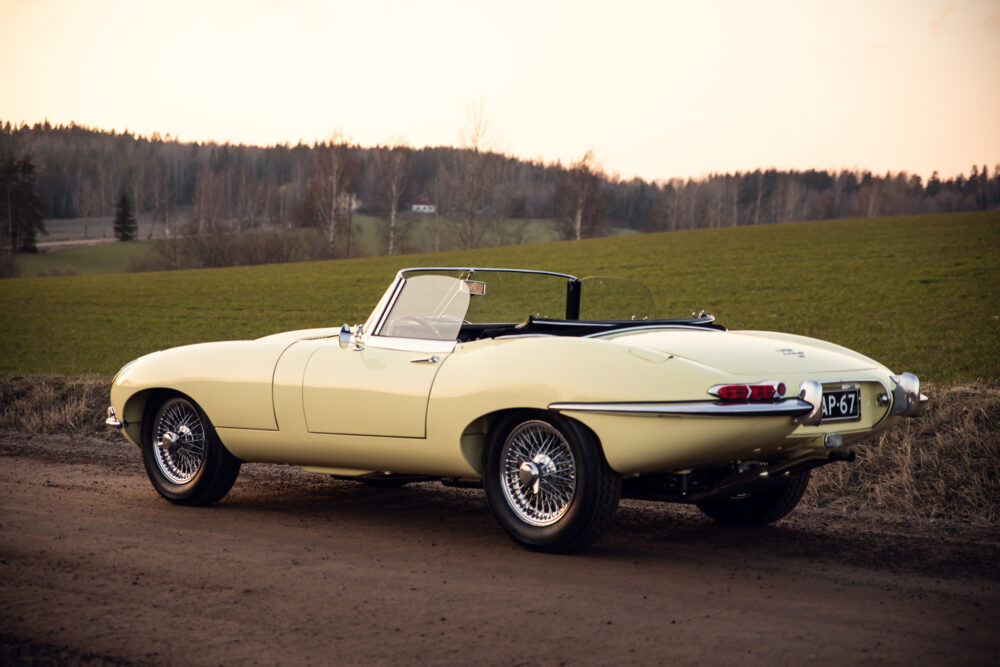 Vintage cream convertible car on rural road at sunset