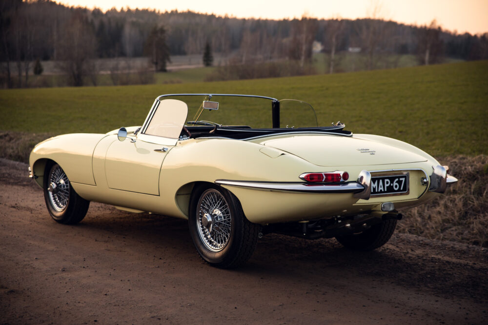 Vintage yellow Jaguar E-Type convertible on country road