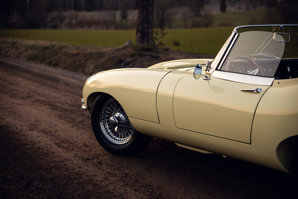 Vintage yellow convertible car parked on dirt road