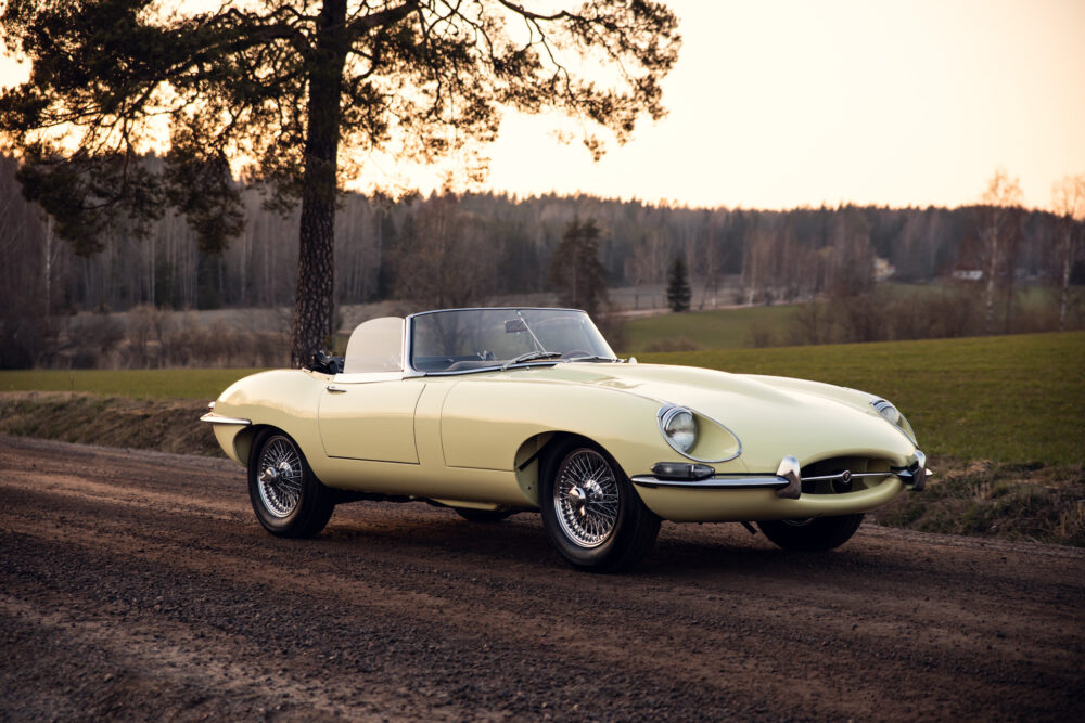 Vintage yellow convertible car parked near forest