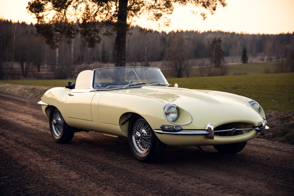 Vintage yellow convertible car on a rural road at sunset