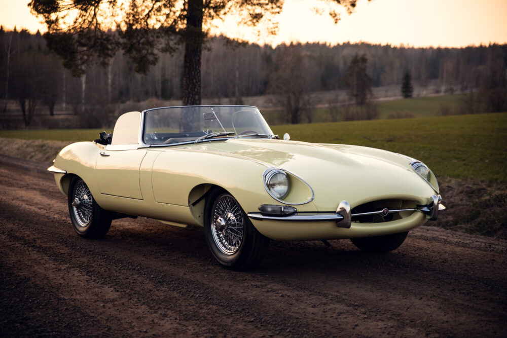 Vintage yellow convertible car on a country road at sunset